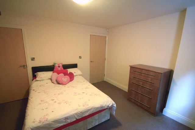 A cozy bedroom featuring a double bed adorned w...