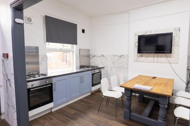 Bright and modern kitchen with blue cabinetry, ...
