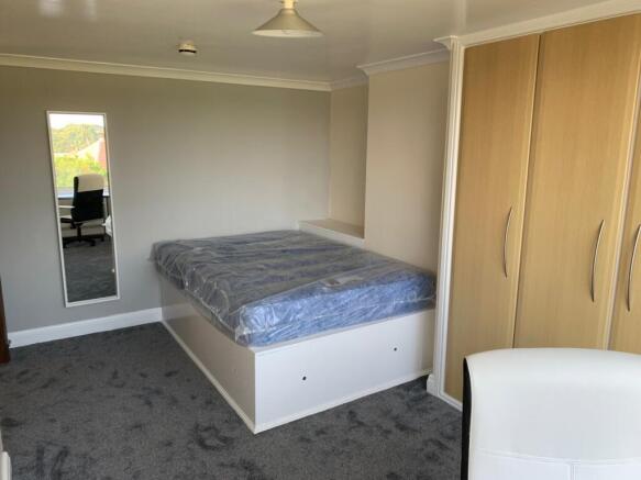 A well-maintained double bedroom featuring a cl...