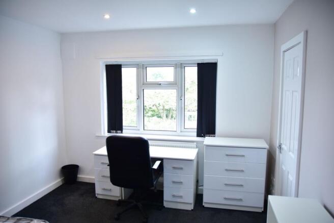 Bright and tidy bedroom featuring a comfortable...