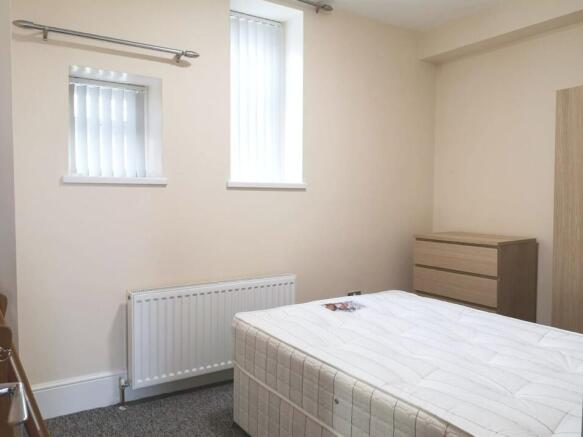 A neat and simple bedroom featuring a comfortab...