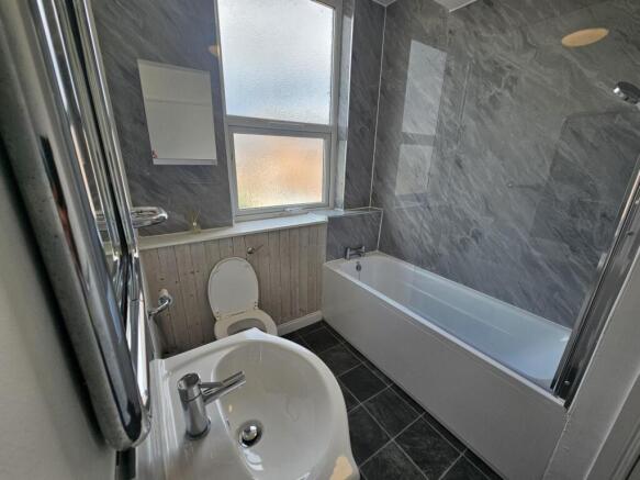 A well-maintained bathroom with a clean bathtub...