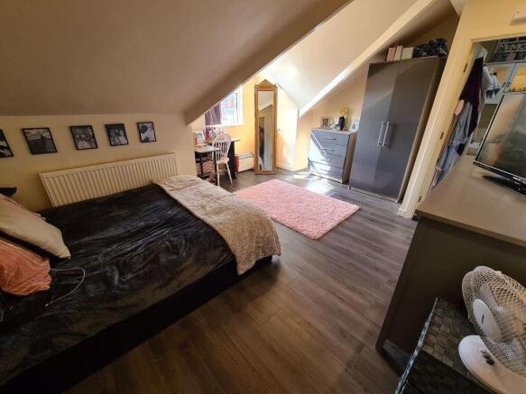 A cozy and well-lit master bedroom featuring a ...