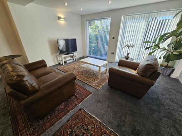 A spacious and well-lit living room featuring c...