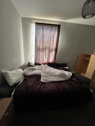 A cozy bedroom featuring a neatly made bed with...