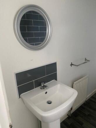 A clean and modern bathroom with a white sink, ...