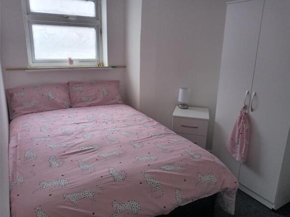 Cozy double bedroom featuring a pink cheetah pr...