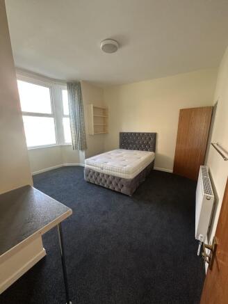 A well-lit, tidy double bedroom with a comforta...