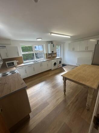 A brightly lit, modern kitchen with white cabin...