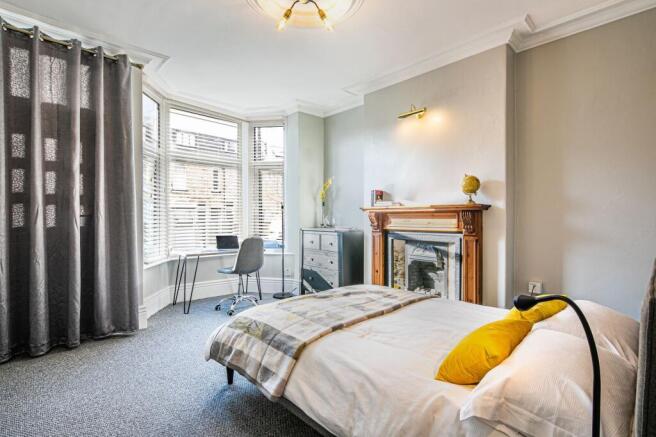 Bright and spacious bedroom featuring a large b...