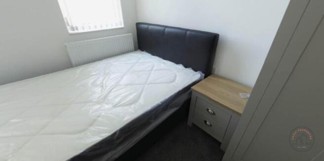 A tidy bedroom featuring a double bed, a small ...