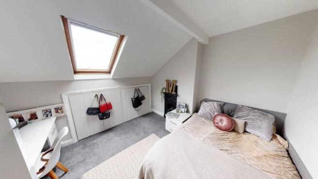 A bright, spacious master bedroom with a cozy b...