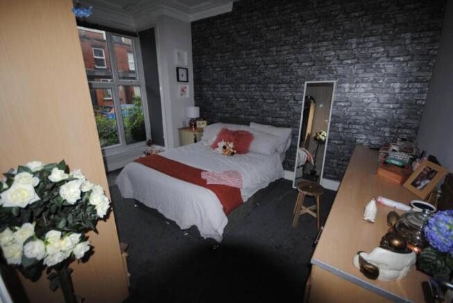 A spacious master bedroom featuring a large bed...