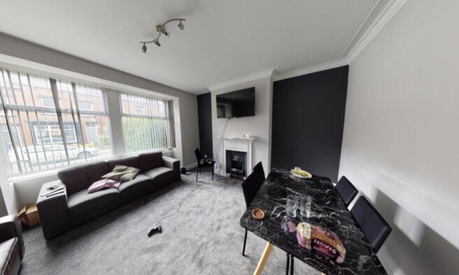 A spacious, well-lit living room with large win...