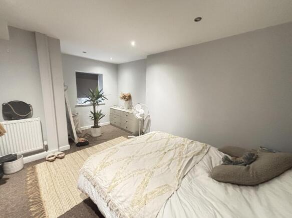 A bright and cozy bedroom featuring a comfortab...