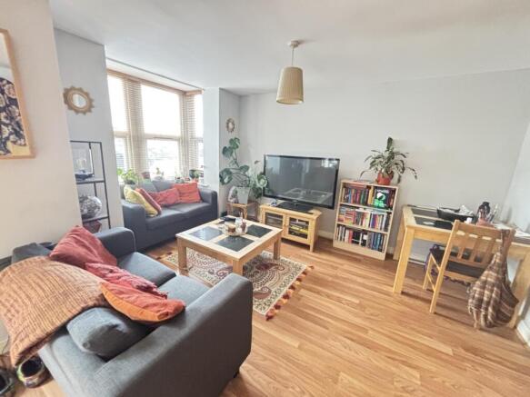 A bright and spacious living room featuring com...