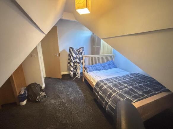 A cozy student bedroom featuring a comfortable ...