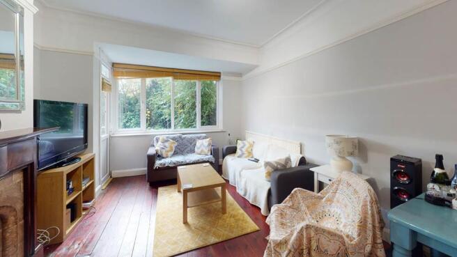 A spacious, well-lit living room with large win...