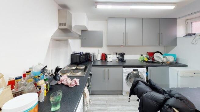 Modern and well-lit kitchen area with ample wor...