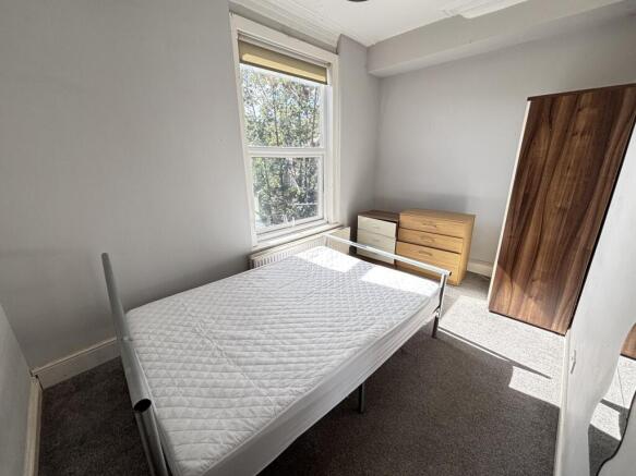 A bright and tidy bedroom featuring a single be...