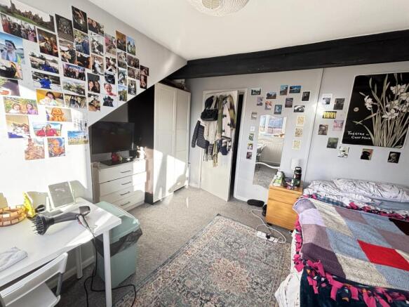 Spacious master bedroom featuring a large bed a...