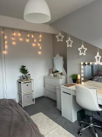 A well-lit bedroom featuring cozy fairy lights,...