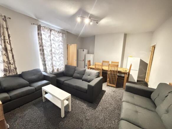 A spacious and well-lit living room featuring a...