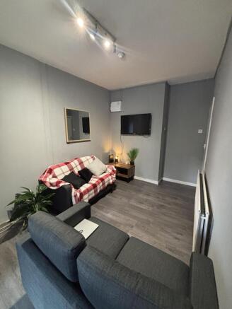 A modern, well-lit living room featuring two co...