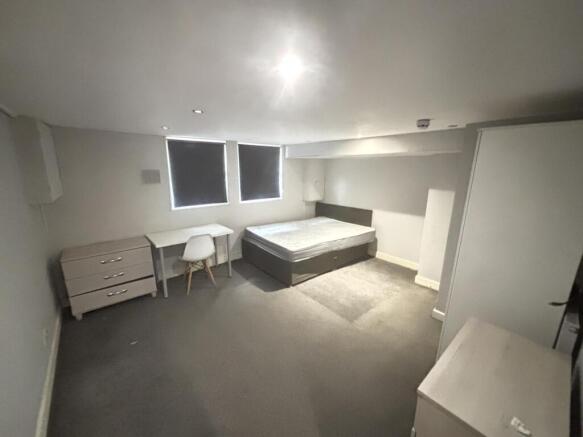 A bright and tidy bedroom featuring a comfortab...