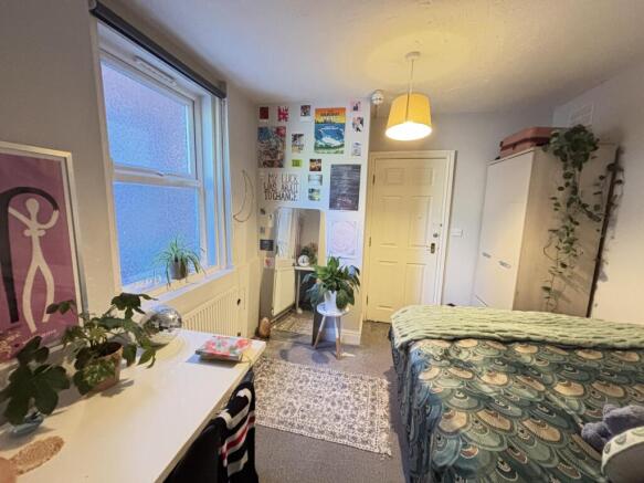 A spacious and well-lit bedroom featuring a lar...