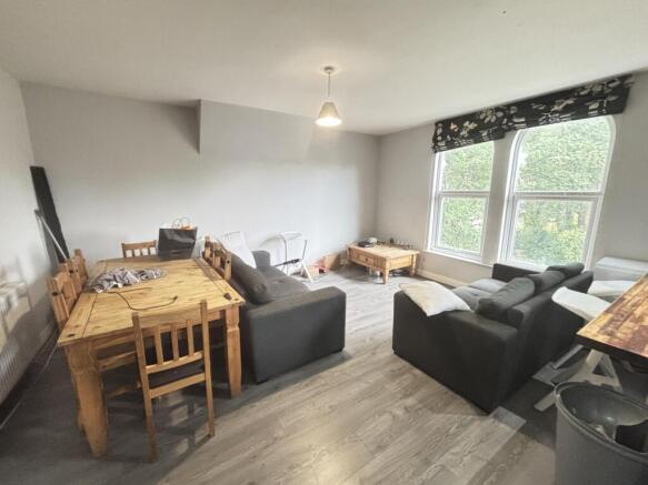 A bright and spacious living room featuring lar...