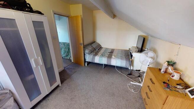 A cozy single bedroom featuring a single bed wi...