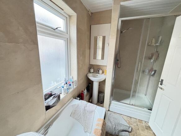 A clean, well-lit bathroom featuring a shower u...