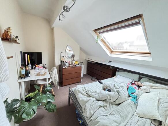 A cozy bedroom with a sloped ceiling featuring ...