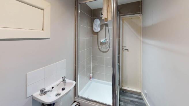 A modern, clean bathroom with a shower unit and...