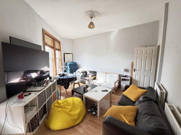 A spacious and well-lit living room featuring m...