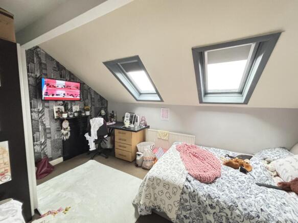 A bright and cozy bedroom with two skylight win...