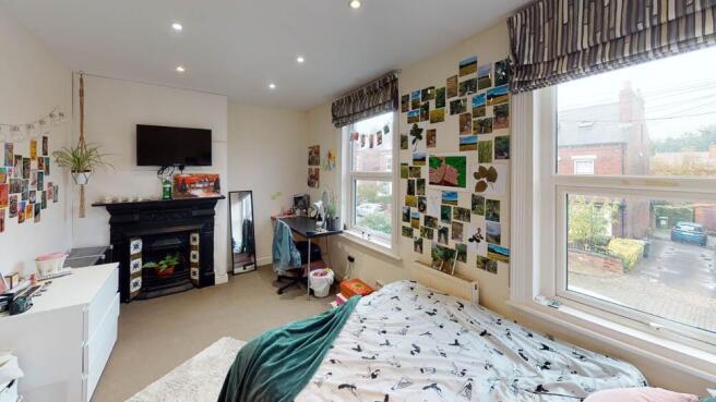 A bright and welcoming bedroom with a large win...