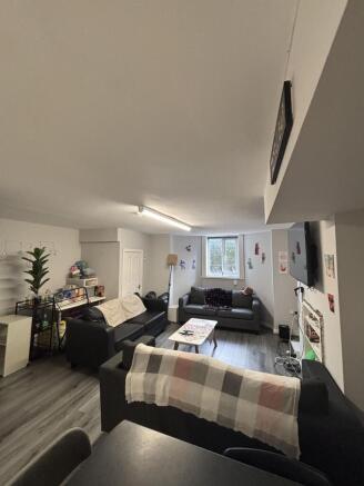 A spacious and well-lit living room with large ...