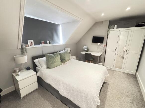 A bright and tidy bedroom featuring a large dou...