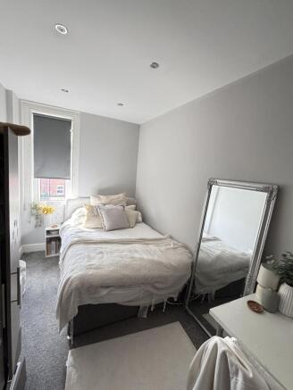 A bright and cozy bedroom featuring a comfortab...