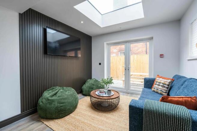 A modern, well-lit living room featuring a larg...