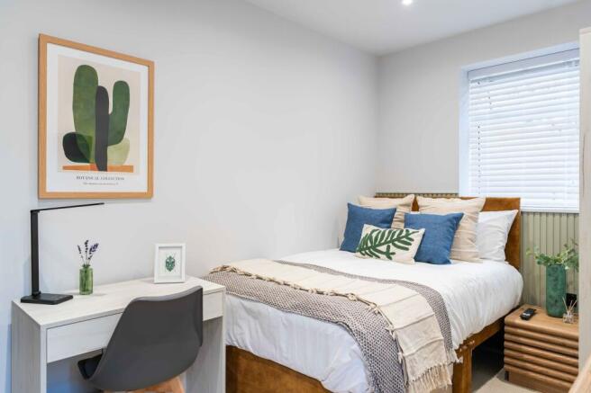 A bright, inviting double bedroom featuring a c...