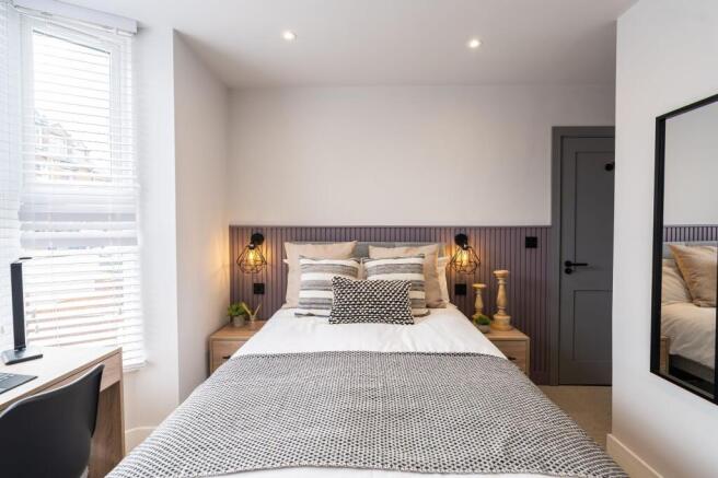 A bright, contemporary master bedroom featuring...