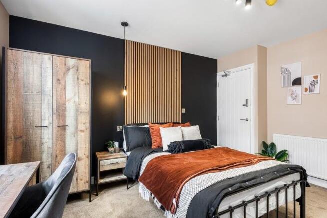 A stylish double bedroom featuring a cozy bed w...