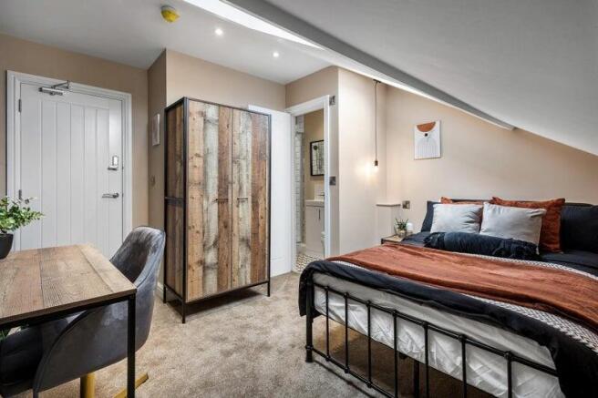 A stylish and cozy master bedroom featuring a c...