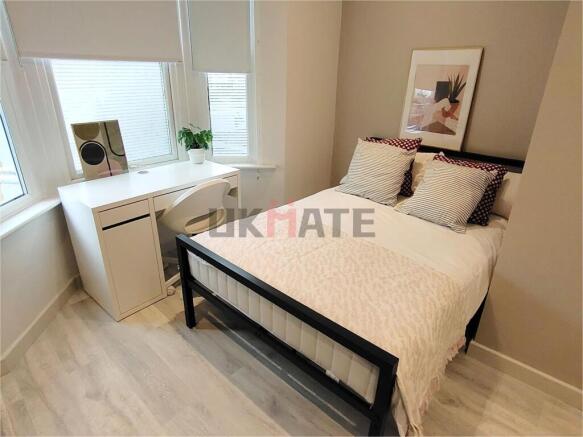 A bright and stylish double bedroom featuring a...