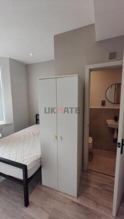 A compact yet inviting bedroom featuring a ward...
