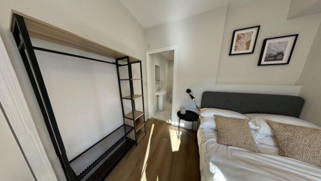 A bright and tidy bedroom featuring a comfortab...