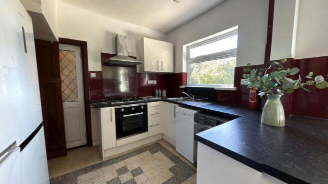 A modern kitchen featuring white cabinets, a bl...
